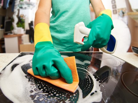 Professional cleaner working on residential windows in Sutton